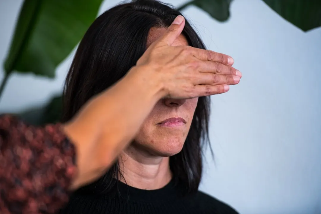 Une participante pratique une induction d’hypnose en recouvrant les yeux de l’autre personne