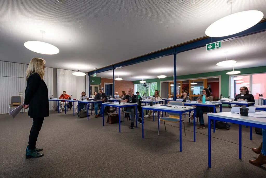 Marta Hegyaljai Python s’adresse à la salle, les participant·e·s assis aux tables