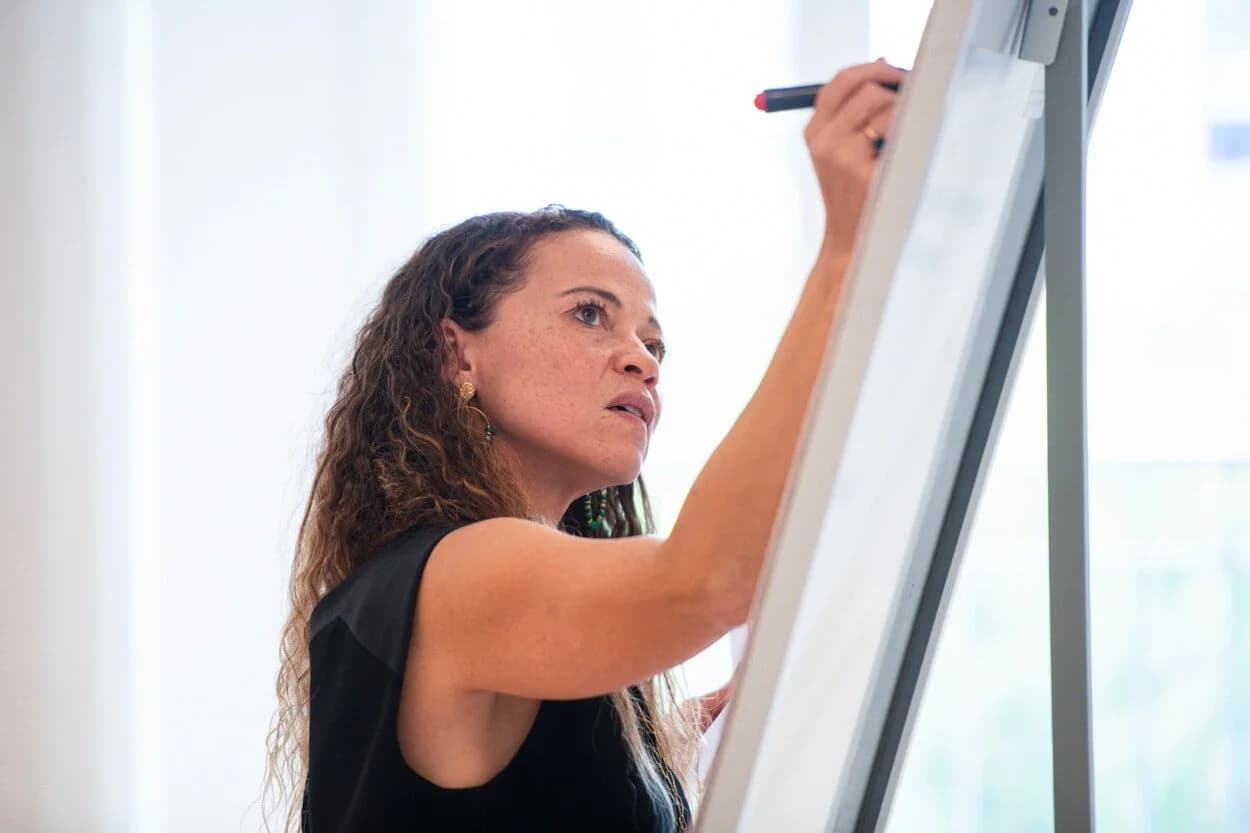 Une participante contribue à un atelier au tableau